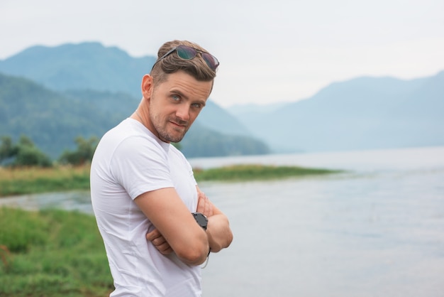 Hombre con los brazos cruzados en el lago