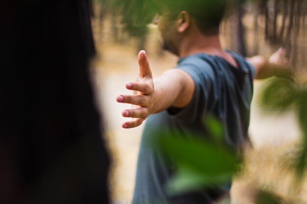 Hombre con los brazos extendidos de pie al aire libre