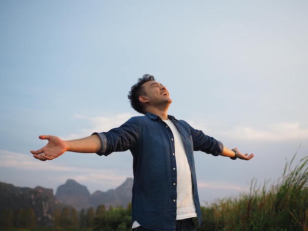 Hombre con los brazos extendidos de pie contra el cielo