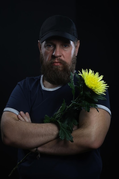 hombre brutal barbudo con una flor