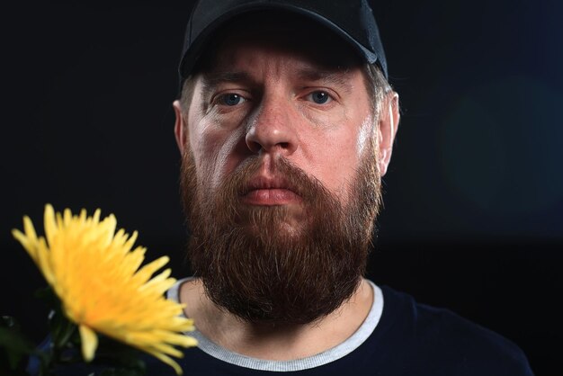 hombre brutal barbudo con una flor