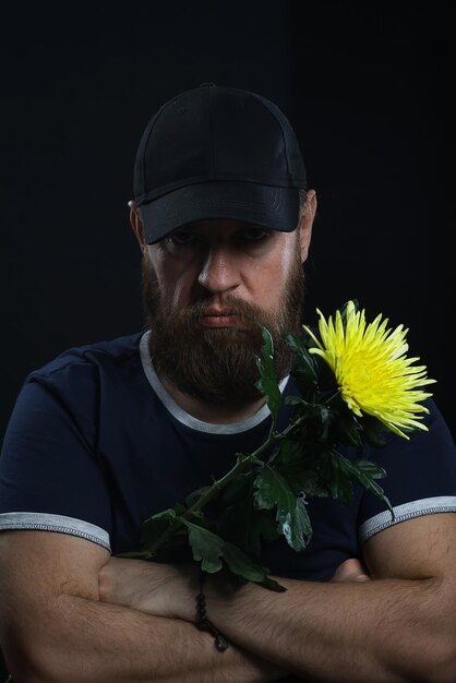 hombre brutal barbudo con una flor