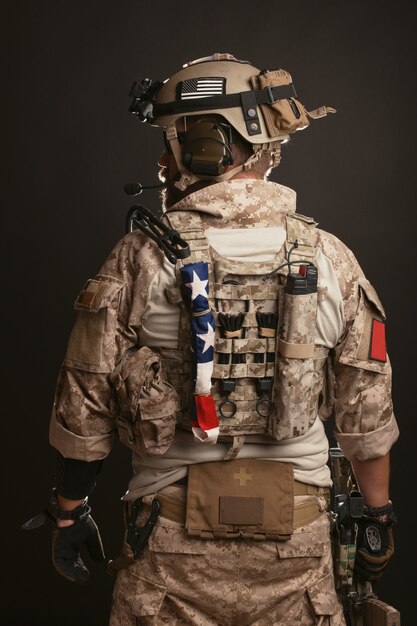 Foto hombre brutal en el uniforme militar del desierto.