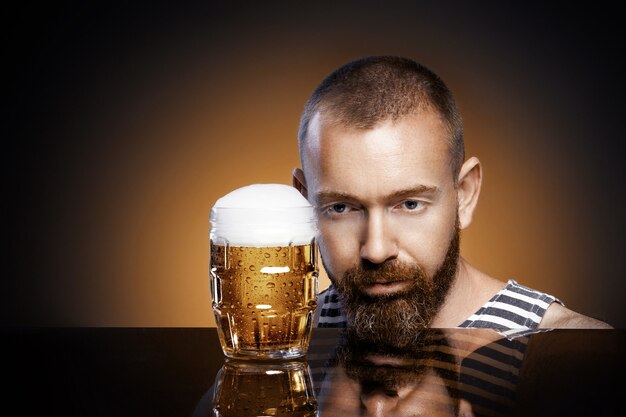 Foto hombre brutal con un vaso de cerveza