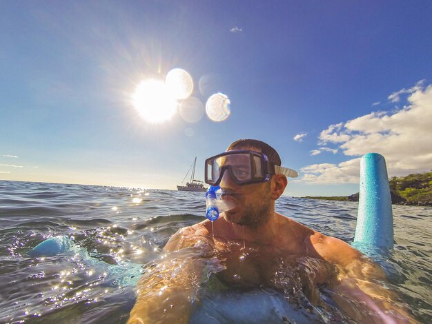 Foto hombre buceando en el pacífico sur tropical desde un ángulo bajo contra el mar