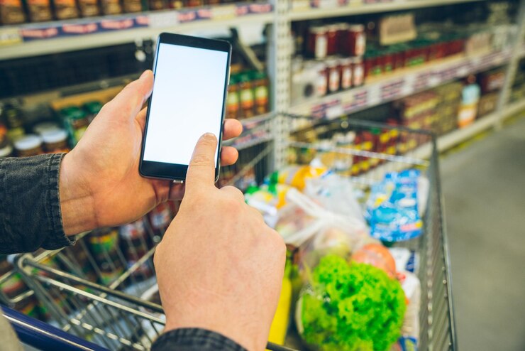 Foto el hombre busca en el teléfono una pantalla blanca de lista de compras para texto