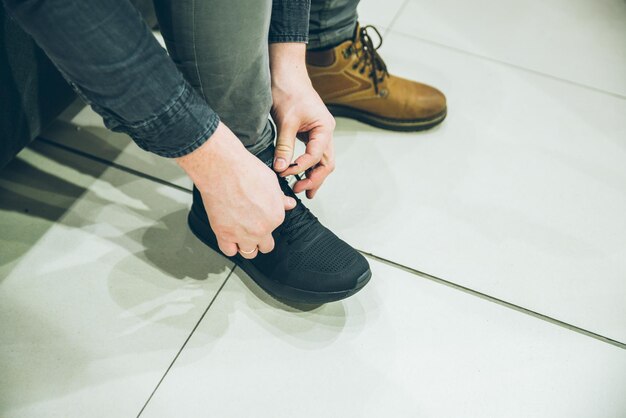 Foto hombre busca zapatillas nuevas en la tienda compras concepto zapatos moda comprar compras