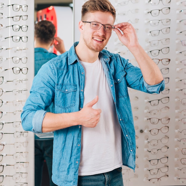 Hombre buscando gafas nuevas en óptico