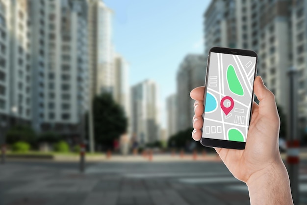 Hombre buscando ubicación con teléfono inteligente en el primer plano de la ciudad Espacio para texto