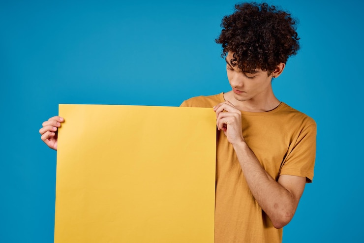 Foto hombre con cabello rizado de astros amarillos en sus manos estudio de fondo azul foto de alta calidad
