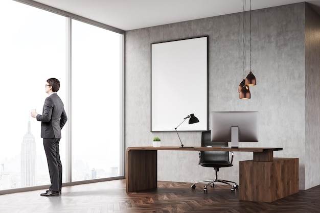 Hombre con café en la oficina del CEO con ventana panorámica y afiche