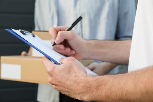 Hombre con cajas y repartidor al aire libre