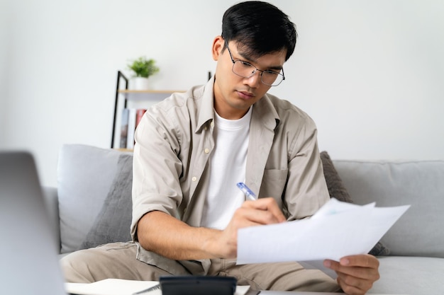 Foto el hombre está calculando el impuesto anual con una calculadora y llenando el formulario de la declaración del impuesto sobre la renta individual