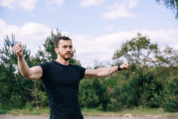 Hombre calentando y estirando los brazos al aire libre en la mañana Salud c