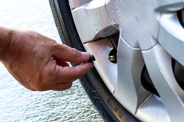Hombre calibrando neumático de coche closeup en mano