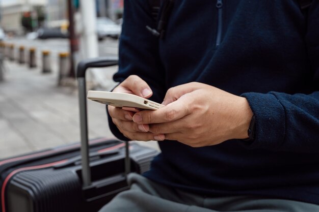 Hombre en la calle del centro de la ciudad pidiendo un taxi usando una aplicación de teléfono inteligente Reservando un taxi usando una aplicación en línea en un teléfono inteligente