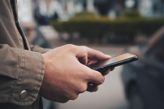 Un hombre se para en la calle y usa el teléfono.