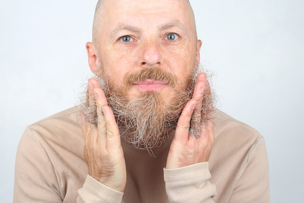 Foto hombre calvo con barba tocando su barba