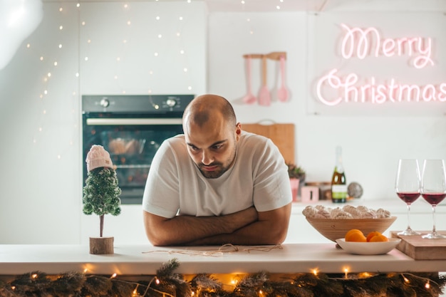 Un hombre calvo inquietante en el fondo de la cocina en la noche de Navidad. Foto de alta calidad