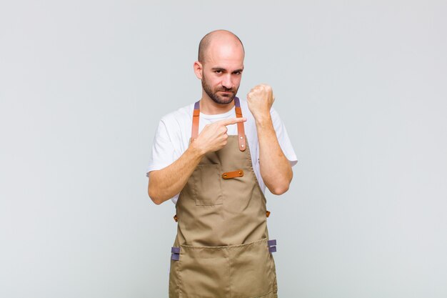 Hombre Calvo mirando impaciente apuntando al reloj