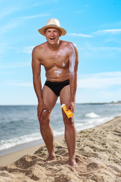 Foto hombre calvo en la playa junto al mar de vacaciones