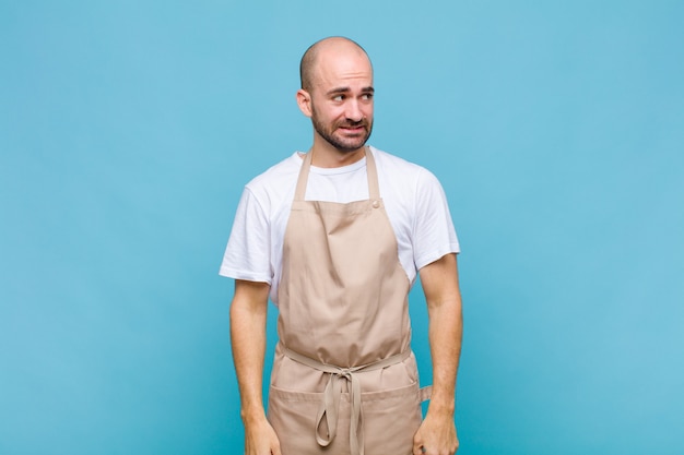 Hombre calvo que parece preocupado, estresado, ansioso y asustado, presa del pánico y apretando los dientes