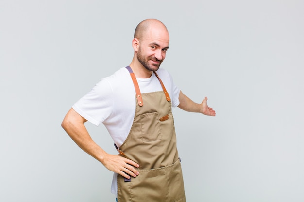 Hombre calvo sintiéndose feliz y alegre, sonriendo y dándote la bienvenida, invitándote con un gesto amistoso