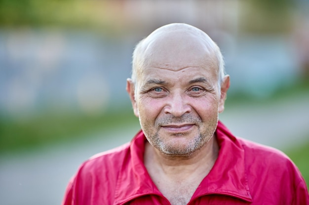 Hombre calvo sonriente en su s con la cara sin afeitar