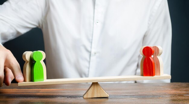 Foto un hombre cambia el equilibrio de la balanza a favor de un grupo verde de personas mediador