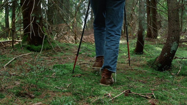 Foto un hombre camina por el bosque con un palo en la mano.