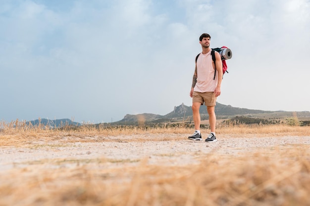 El hombre camina con una mochila de un excursionista a través de un paisaje montañoso