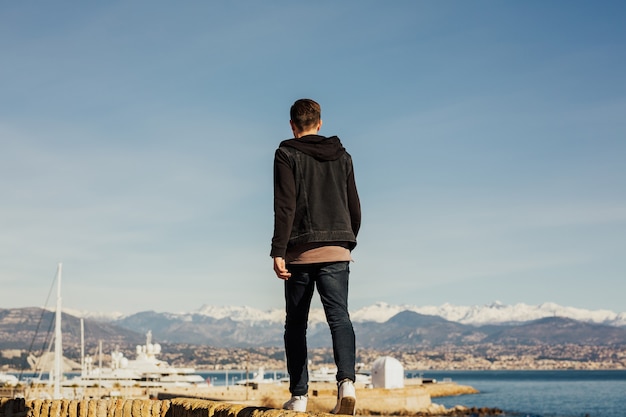 hombre camina por el paseo marítimo y disfruta de la vista del mar.