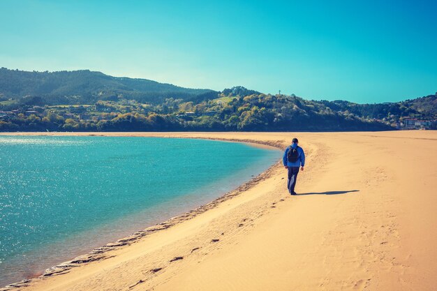 Un hombre camina por la playa El hombre mira el mar