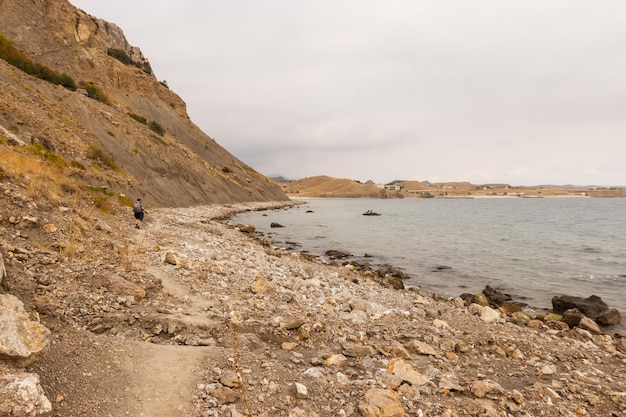 Un hombre camina por una playa rocosa del Mar Negro