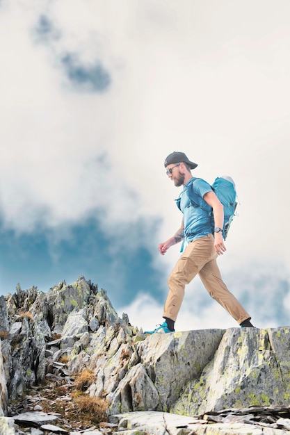 El hombre camina entre rocas en las montañas