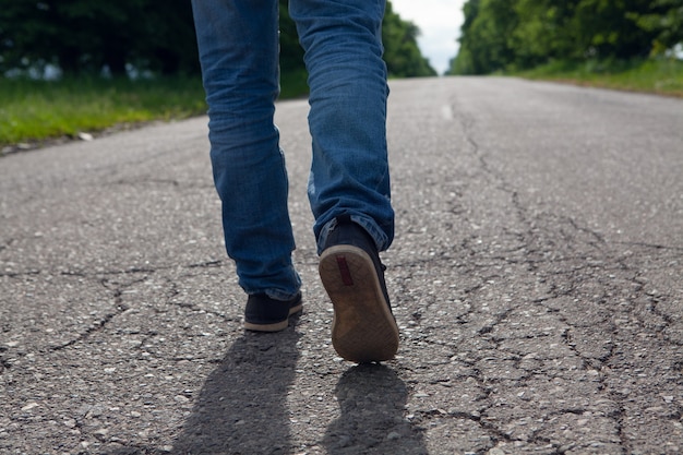 Un hombre camina sobre una carretera asfaltada por la noche