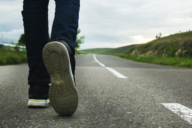 Un hombre camina sobre una carretera asfaltada por la noche