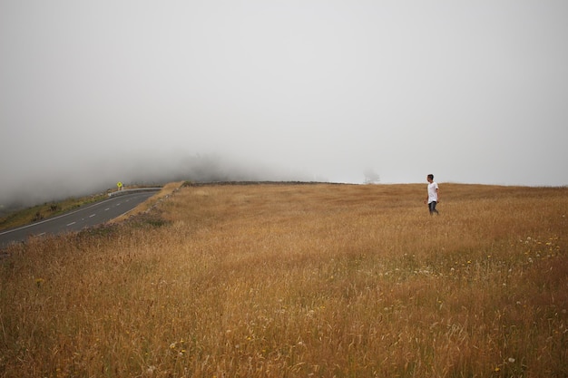 Hombre caminando por el campo contra el cielo