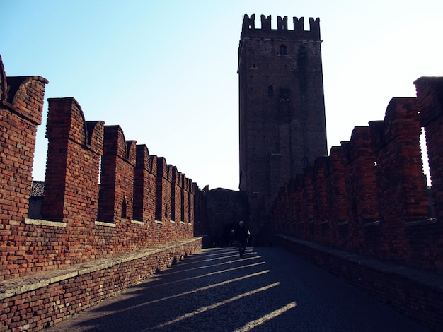 Foto hombre caminando por la carretera que conduce hacia castelvecchio