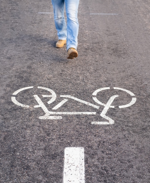 Hombre caminando en un carril bici separado para andar en bicicleta rompiendo las reglas.