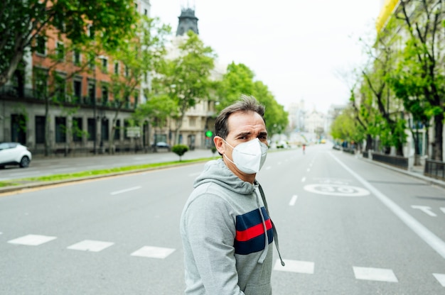 Hombre caminando por la ciudad de Madrid con máscara