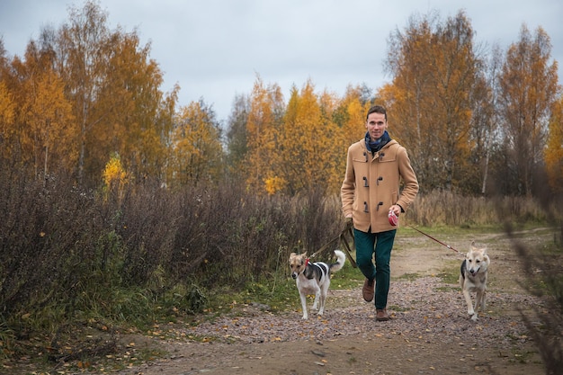 Hombre caminando con dos perros afuera