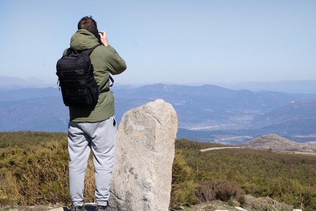 Hombre caminando mirando un paisaje con una mochila Concepto de estilo de vida caminata al aire libre