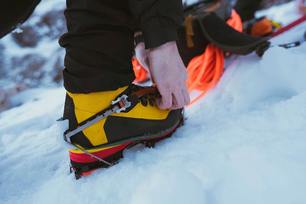 Hombre caminando en la nieve con crampones