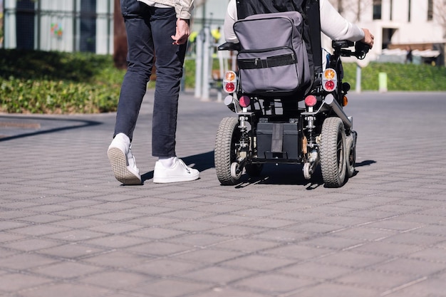 Hombre caminando con una persona en silla de ruedas