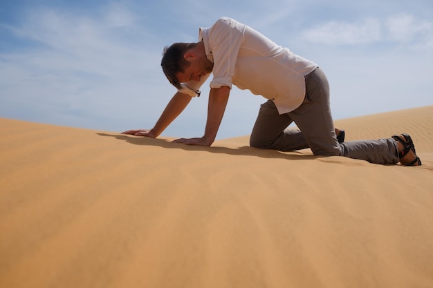Hombre caminando solo en el soleado desierto está perdido y sin aliento sin agua ni energía