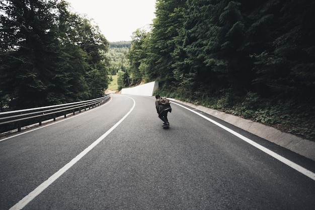 Foto hombre en el camino en medio de los árboles