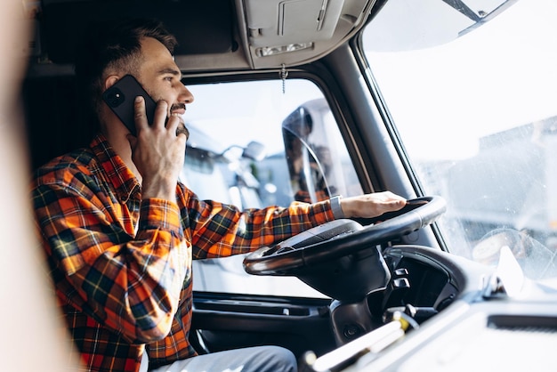 Hombre camionero conduciendo en una cabina de su camión