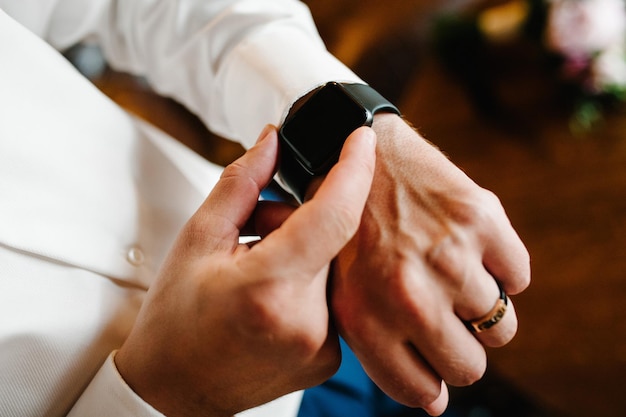 Hombre con camisa ajusta el reloj en su brazo Cerca del hombre de negocios usando reloj