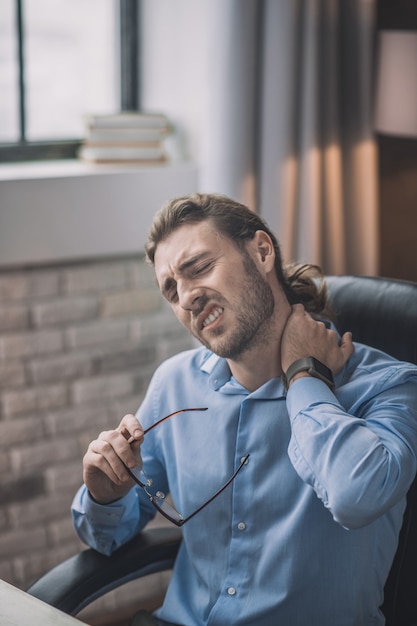 Hombre de camisa azul con aspecto cansado